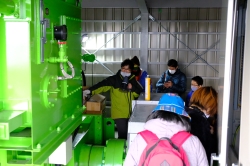 波力発電所の内部に緑色の機械が並んでいる