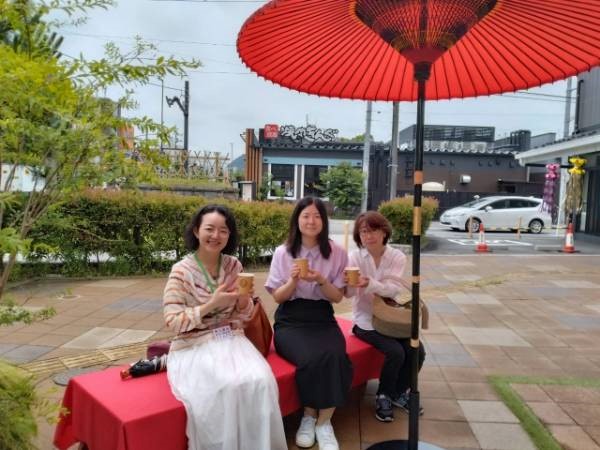 野点傘の下でお茶を飲む写真