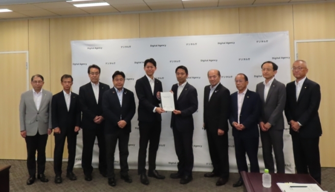 9市町の首長らがデジタル庁政務官に要請書を渡す写真