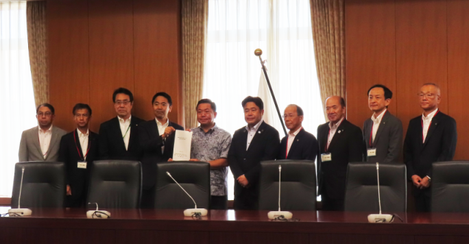 9市町の首長らが文部科学省政務官に要請書を渡す写真