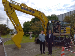 コマツ湘南工場で開催されたコマツ湘南工場フェアで建設機械の前で記念撮影する市長の様子